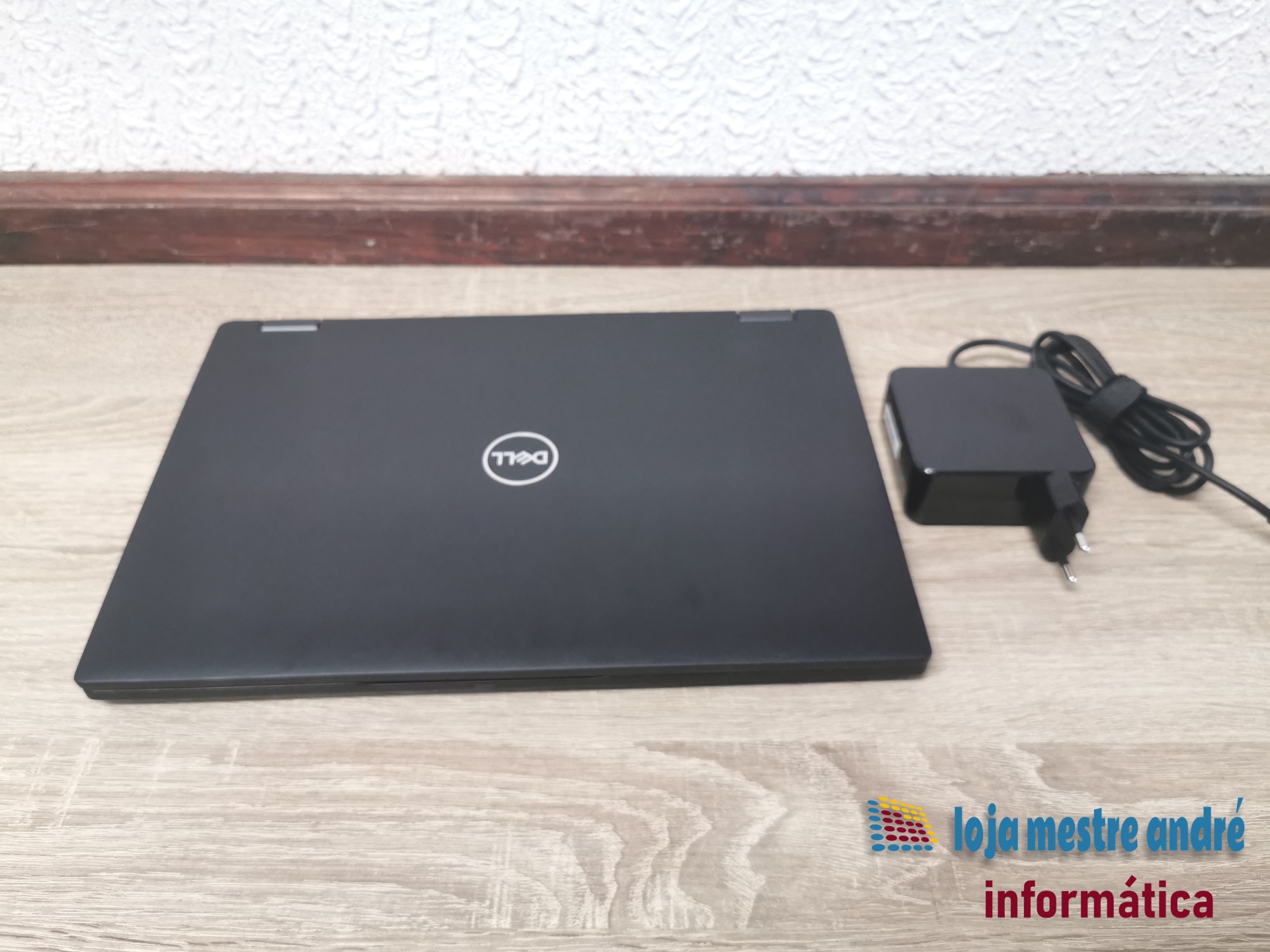 DELL Latitude 7390 2-in-1 Computador portátil Dell preto fechado com carregador preto ao lado