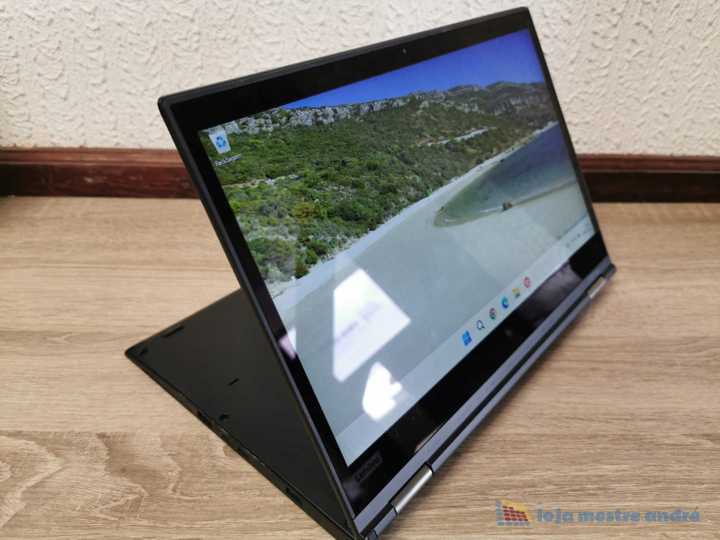 Computador portátil LENOVO Thinkpad X380 Yoga Touch-Screen IPS Full HD Intel Core i5 SSD 256GB Windows 11 PRO Computador portátil preto em modo tablet com ecrã táctil a mostrar uma paisagem costeira.