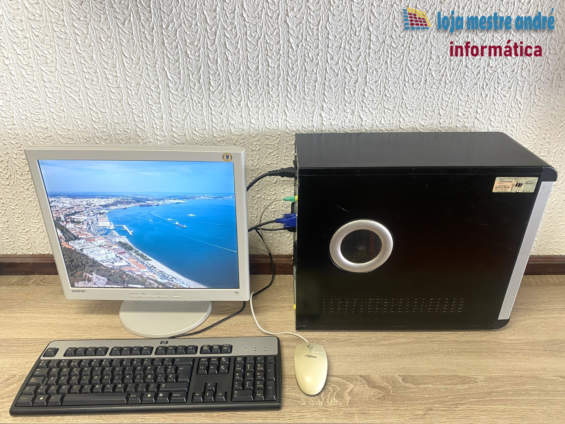 LMA B3 Computador desktop, monitor LCD, teclado HP, rato Fujitsu Siemens sobre mesa de madeira.