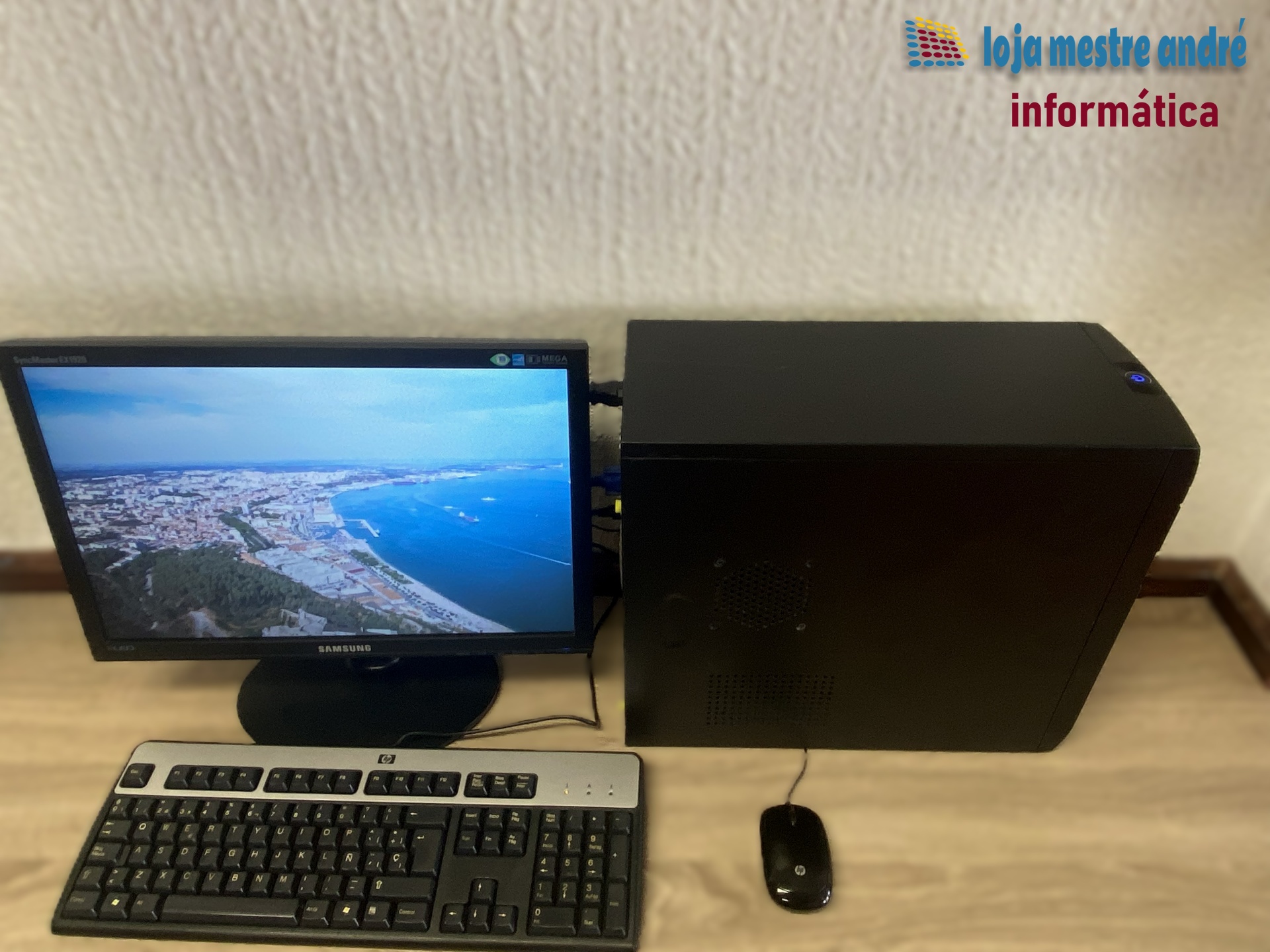 TSUNAMI Computador de secretária com monitor Samsung, teclado HP, rato HP e torre preta.