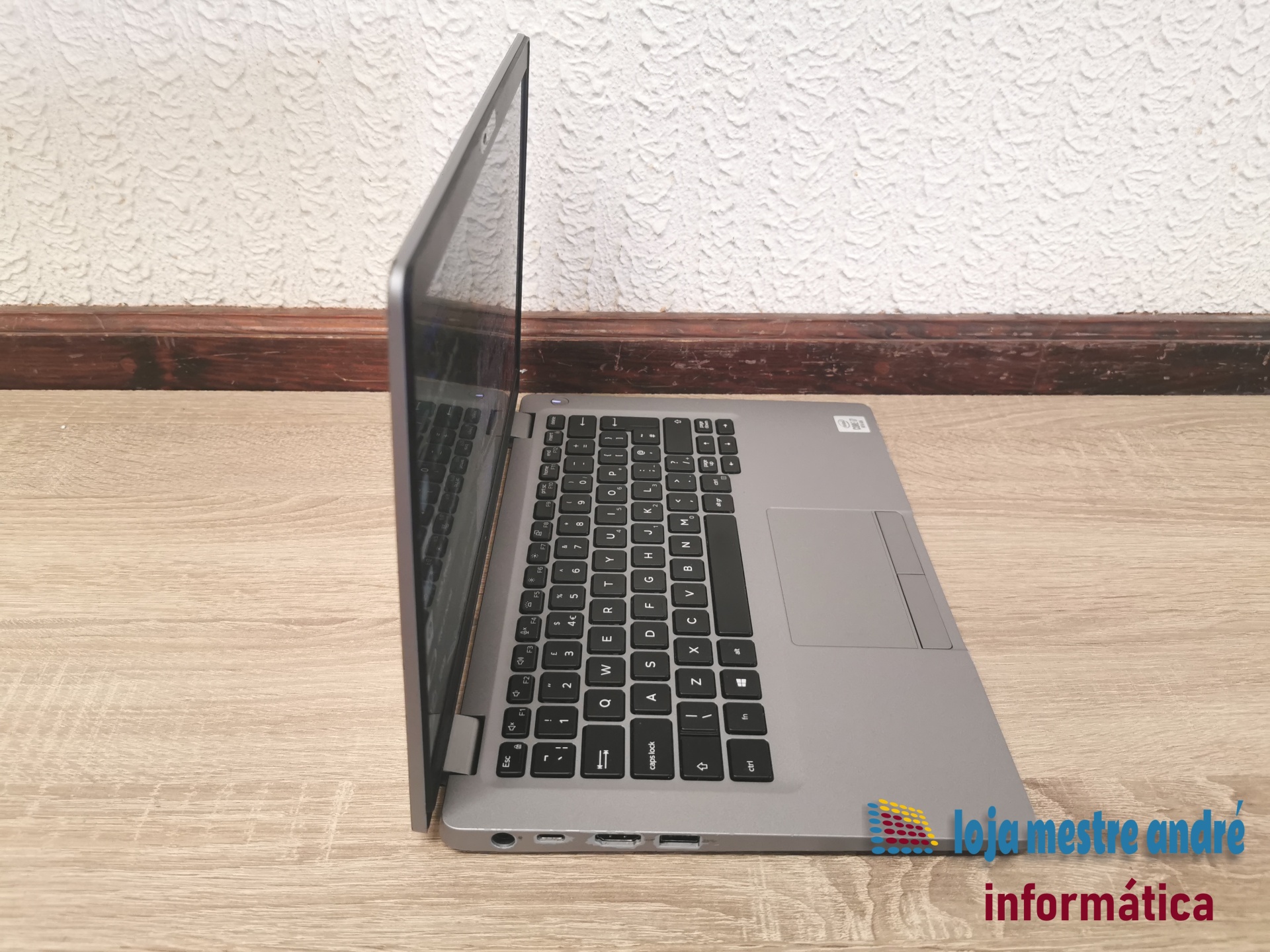 DELL Latitude 5310 Portátil cinzento aberto com teclado preto sobre superfície de madeira