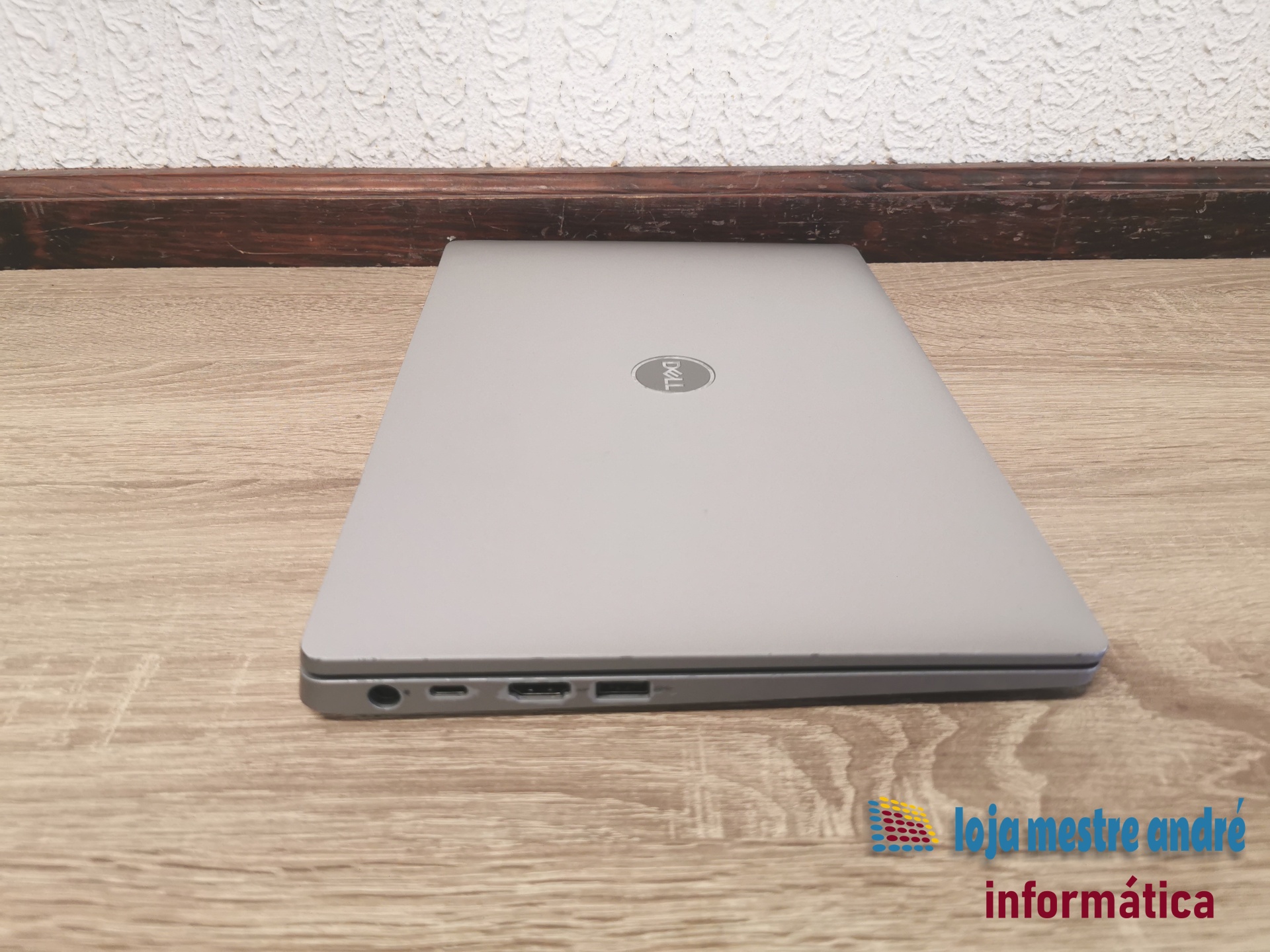 DELL Latitude 5310 Portátil Dell fechado cinza prateado sobre superfície de madeira