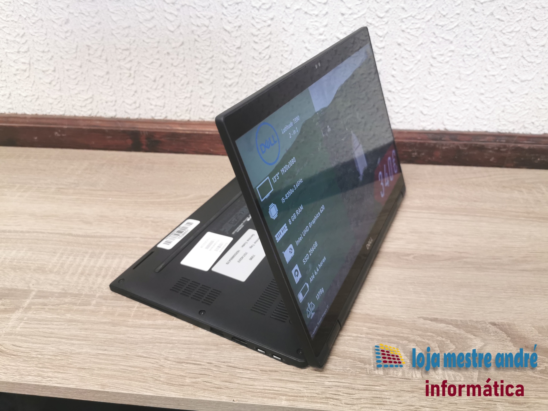 DELL Latitude 7390 2-in-1 Computador portátil 2-em-1 Dell Latitude 7390 preto sobre mesa de madeira com parede branca ao fundo