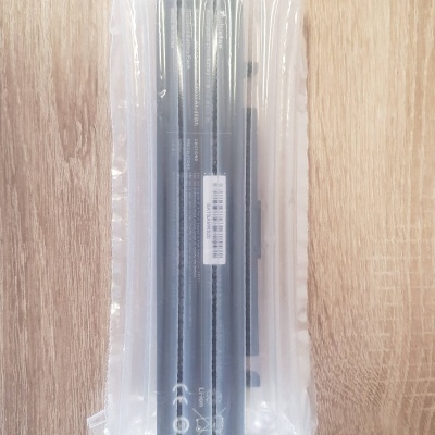 Bateria de portátil em embalagem de plástico insuflável transparente sobre madeira clara