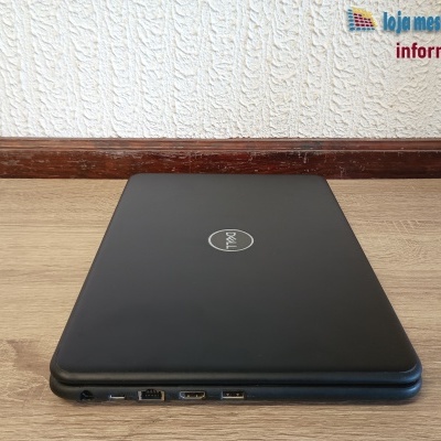 Computador portátil Dell preto fechado sobre mesa de madeira