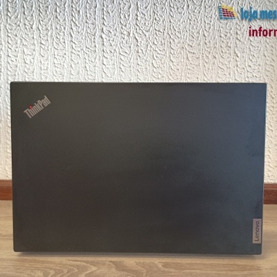 Computador portátil Lenovo ThinkPad preto em madeira com parede texturada branca atrás