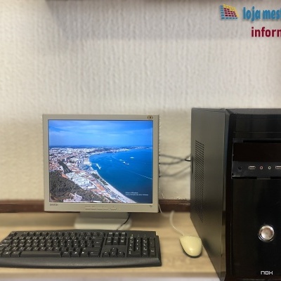 Computador desktop com torre preta, monitor CRT e teclado sobre mesa
