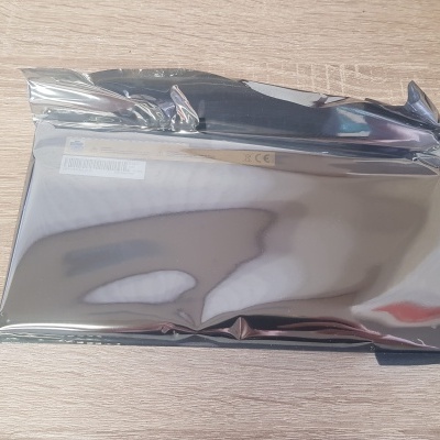 Embalagem metalizada prateada sobre superfície de madeira clara