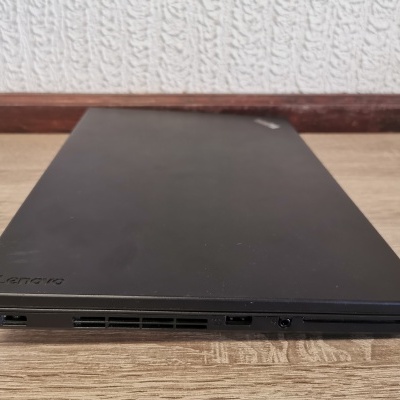 Computador portátil Lenovo preto fechado sobre mesa de madeira clara