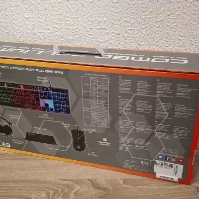 Caixa de conjunto gaming com teclado RGB, auscultadores, rato e tapete em fundo de madeira