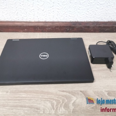 Computador portátil Dell preto fechado com carregador preto ao lado