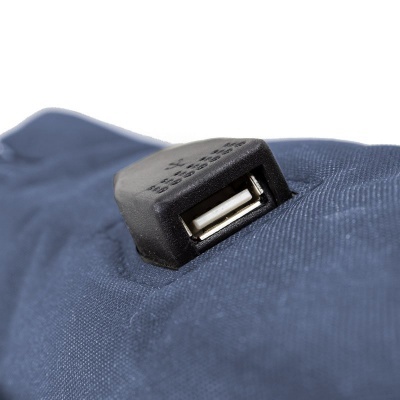 Tomada USB preta numa superfície de tecido azul escuro com textura visível