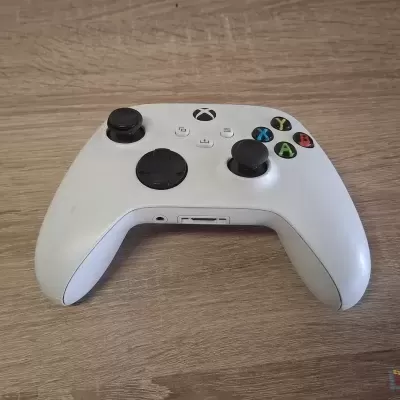 Comando Xbox Series S branco sobre mesa de madeira clara