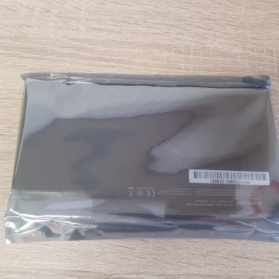 Pacote antiestático com componente eletrônico preto sobre superfície de madeira