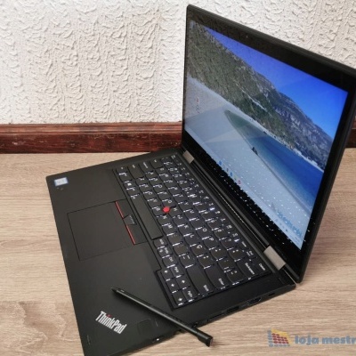 Computador portátil Lenovo ThinkPad aberto com ecrã a mostrar uma praia, colocado no chão de madeira junto a parede branca