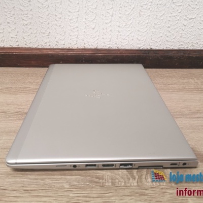 Computador portátil HP prateado fechado junto à parede