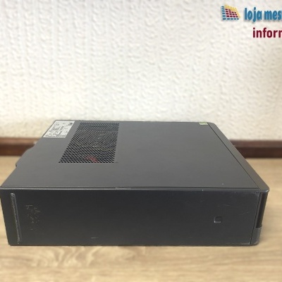 Computador desktop preto com grelha de ventilação sobre mesa de madeira clara