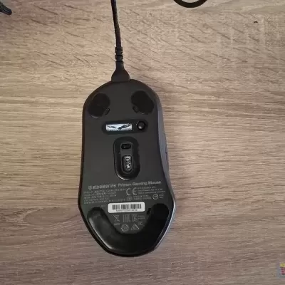 Mouse de computador preto com cabo sobre mesa de madeira clara