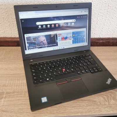 Portátil Lenovo ThinkPad preto sobre mesa de madeira clara com parede texturizada ao fundo