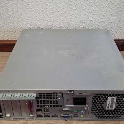 Caixa de computador desktop cinzenta vista por trás com portas e slots visíveis