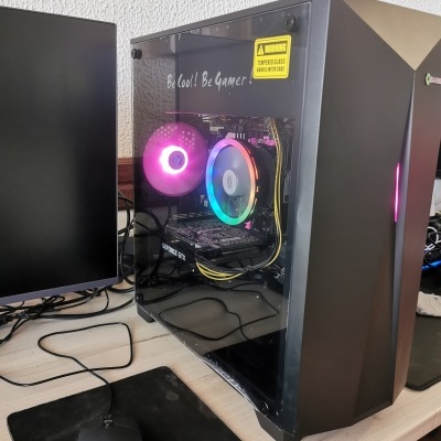 Computador de secretária preto com visão lateral em vidro temperado com iluminação LED RGB.