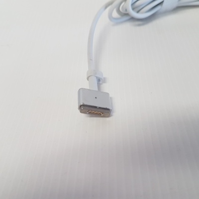 Cabo branco com conector magnético e pinos dourados sobre fundo branco texturado