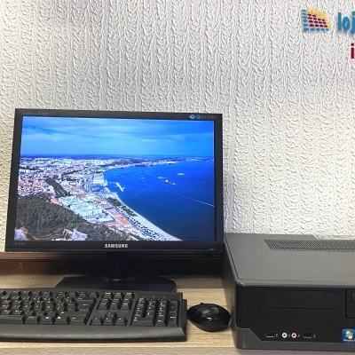 Computador de secretária Fujitsu com monitor, teclado e rato em fundo branco texturado