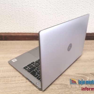 Computador portátil prata com teclado preto sobre mesa de madeira