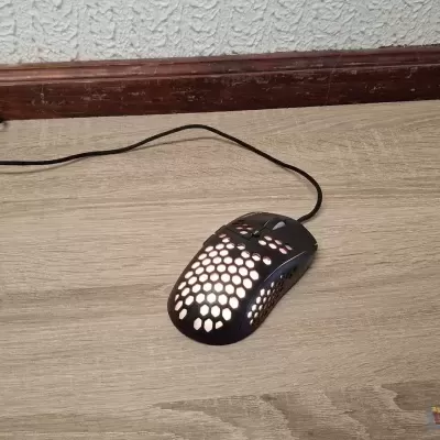 Rato preto perfurado com cabo numa superfície de madeira