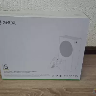Caixa da consola Xbox Series S branca numa sala com chão de madeira