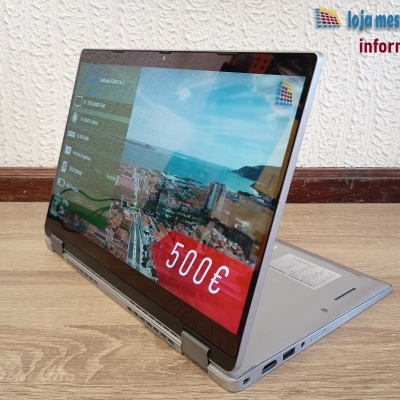 Computador portátil prateado em modo tablet com ecrã táctil e preço 500€