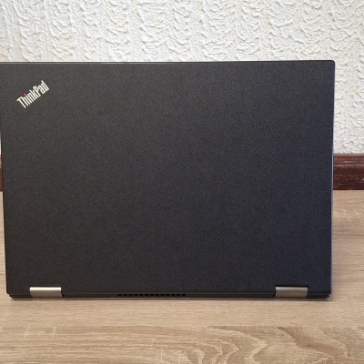 Computador portátil preto ThinkPad fechado sobre superfície de madeira clara