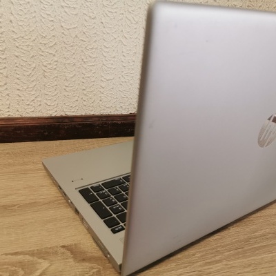 Computador portátil HP cinza prateado sobre superfície de madeira clara