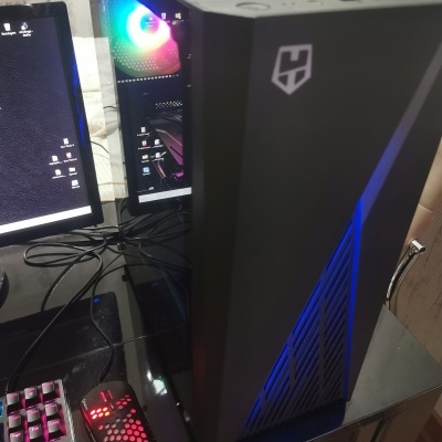 Computador desktop preto com LED RGB, teclado mecânico e rato iluminado numa secretária preta