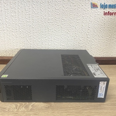 Computador torre preto sobre chão de madeira e parede texturada branca