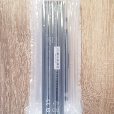 Bateria para portátil em embalagem plástica sobre superfície de madeira clara