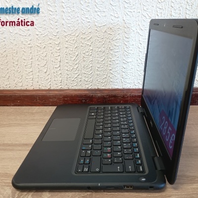 Computador portátil preto Dell com preço 285€ numa mesa contra parede branca