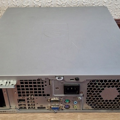 Parte traseira de computador de secretária cinzento com várias portas e cooler