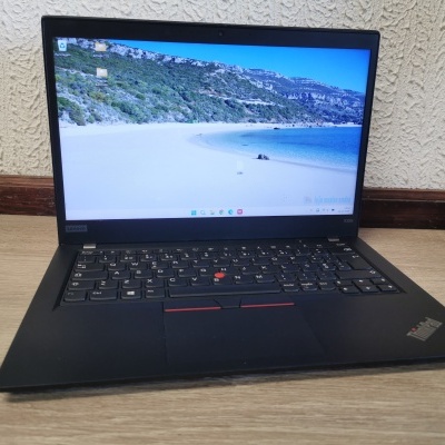 Computador portátil Lenovo ThinkPad X395 aberto em cima de mesa de madeira clara