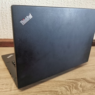 Computador portátil preto da marca ThinkPad sobre mesa de madeira clara