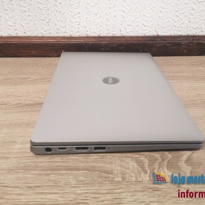 Portátil Dell fechado cinza prateado sobre superfície de madeira