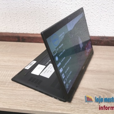 Computador portátil 2-em-1 Dell Latitude 7390 preto sobre mesa de madeira com parede branca ao fundo