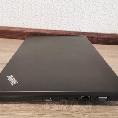 Computador portátil preto fechado ThinkPad numa superfície de madeira