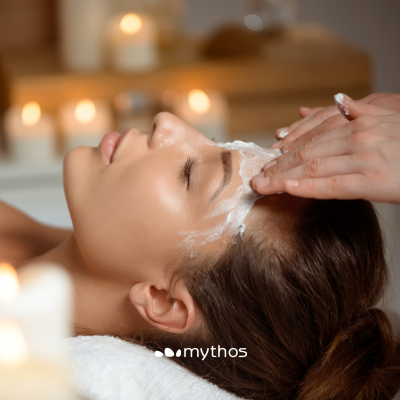 Pessoa a receber aplicação de creme na testa num ambiente com velas acesas e relaxante