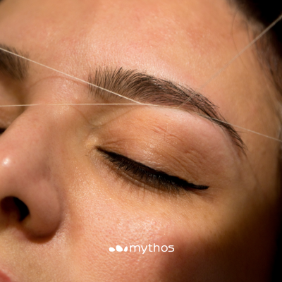 Depilação de sobrancelha com linha branca em pele clara, com maquilhagem preta no olho e logótipo mythos