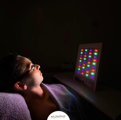 Painel de luz LED colorida com mulher de olhos fechados deitada e iluminada