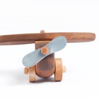 avião de brinquedo de madeira castanho e azul claro, fundo branco