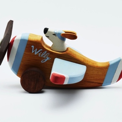 Avião de brinquedo em madeira com hélice e figura de cão piloto