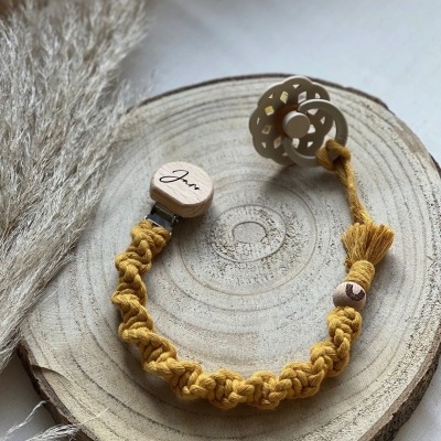 prendedor de chupeta amarelo com clip de madeira texto Jura e chupeta cinza