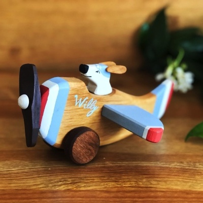 Brinquedo avião em madeira com cachorro ao volante e texto 'Willy'